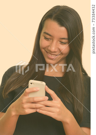 Young happy Caucasian woman smiling and using mobile phone 73384432