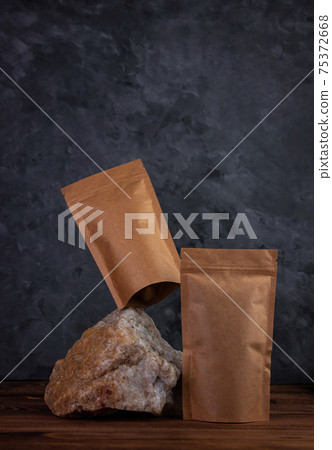 Balancing pouch bag mockup natural stone. Blank kraft paper pack with coffee beans dark background. Equilibrium floating 75372668