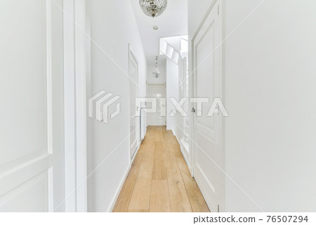 Narrow corridor with doors and lamp 76507294