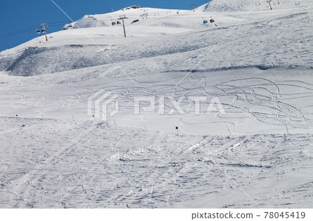 Snowy ski slope with trace from skis and snowboards at nice sun day 78045419