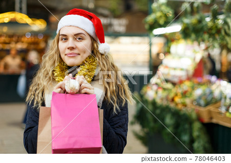 Woman holding bags with Christmas toys 78046403