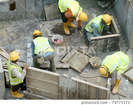 MALACCA, MALAYSIA -JANUARY 31, 2017: Drainage work by construction workers. Construction workers installing precast u-shape concrete drain at the construction site.  79773173