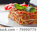 Extra close up view to piece of lasagna with basil 79999779