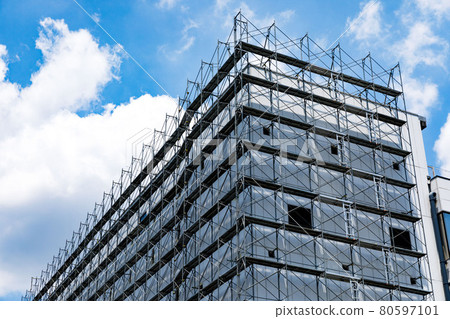 Building renovation work site framework scaffolding and blue sky 80597101