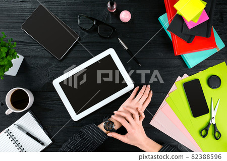 Mix of office supplies and gadgets on a wooden desk background. View from above. 82388596