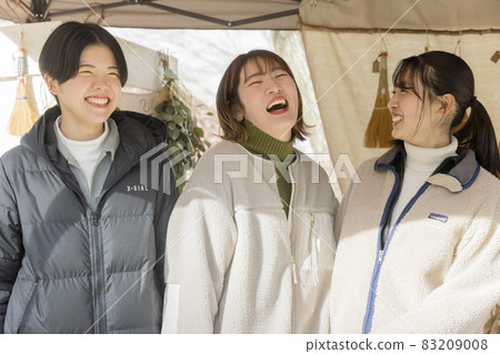 Young women having a conversation in front of the Marche shop Craft Fair 83209008