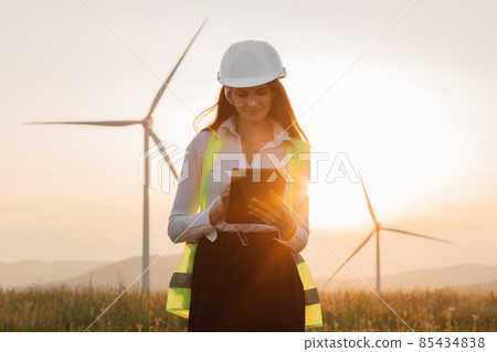 Woman in helmet working with tablet at renewable energy farm 85434838