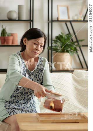 Woman Pouring Cup of Tea 85264007