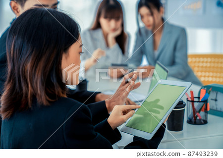 Businesswoman in business meeting using computer proficiently at office room . 87493239