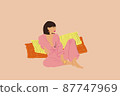 Young brunette woman in blue pyjama sitting relaxed on beige background 87747969