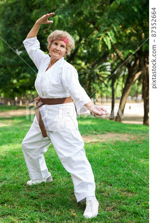 Old lady exercising karate in park 87352664