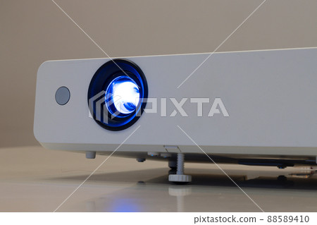 close up the lens of the projector with light for presentation in a dark room presention 88589410