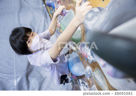 Elementary school girl in a mask bouldering 88091081