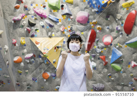 Bouldering image Elementary school student in a mask doing a guts pose in front of the wall 91558710