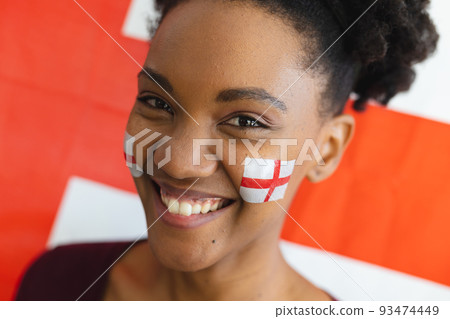 Image of happy african american woman with flags of england on face over flag of england 93474449