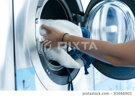 Hand of woman laundry by the washing machine 93666903