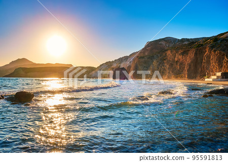 Beautiful low sun over sea and rocky shores, Fyriplaka beach, Milos, Greece.  95591813