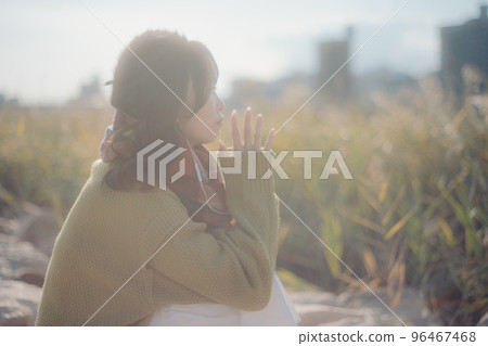 A photo of a young woman standing on the riverbed while listening to music 96467468