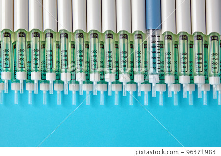 Diabetic insulin pens lined up on a blue background. Provision o 96371983