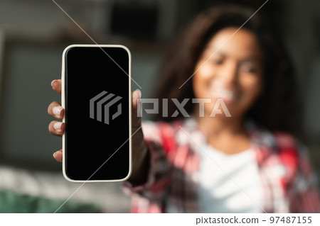 Happy millennial black woman show smartphone with blank screen, recommending app, website 97487155