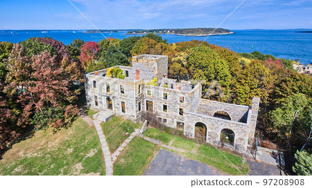 Aerial over old abandoned stone structure in great condition with Maine ocean in background 97208908