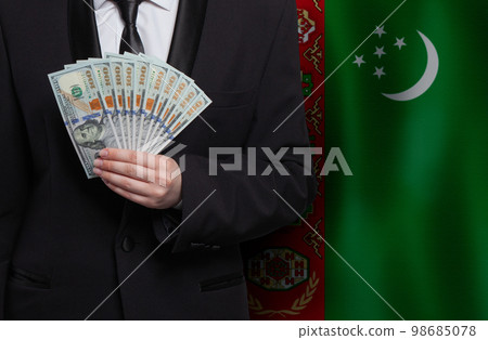 US dollar bills money banknotes in hand against flag of Turkmenistan background 98685078