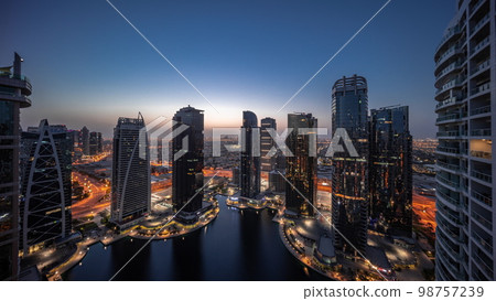 Tall residential buildings at JLT aerial night to day , part of the Dubai multi commodities centre mixed-use district. 98757239