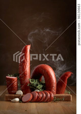 Smoked sausage with thyme and garlic on a wooden table. 98130663