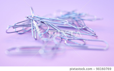 Paper clips together in pile, connected and a chain on purple background. Office supplies, organization and project management with paperclip for business strategy and planning to organize paperwork. 98160769