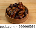 Dates fruits in wooden bowl on wooden background close up. Eating dried fruits. Vegan, vegetarian food 99999564