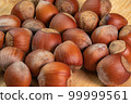 Hazelnuts in shells on wooden background close up. Whole and shelled organic hazelnuts on a wooden table. Nut in shell video concept 99999561