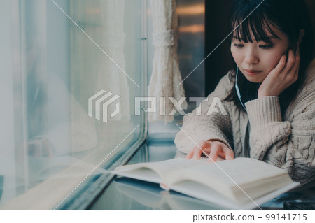 Photo of a woman reading in a coffee shop 99141715