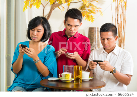 Asian people having fun with mobile phone 6665584