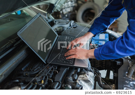 Auto mechanic using laptop 6923615