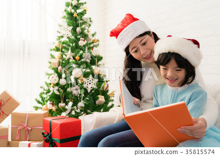 mom reading a book to her cute daughter 35815574