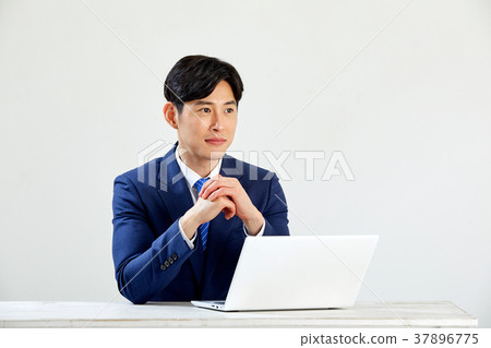 Twenty-something business man sitting and working on a laptop 37896775