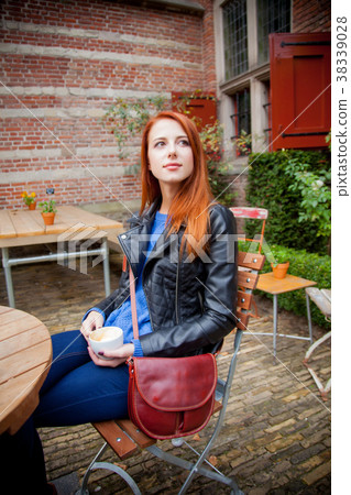 Young redhead girl in hat in a cafe in Amsterdam 38339028