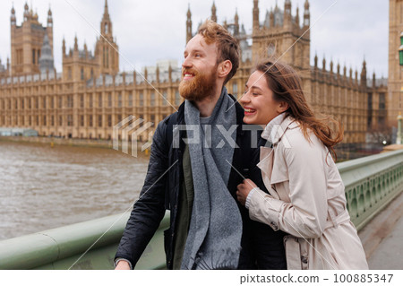 Happy young couple walks holding hands against the background of London's Big Ben 100885347