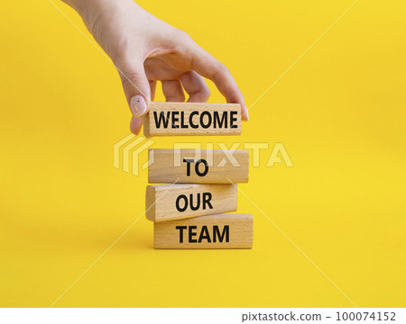 Welcome to our team symbol. Concept words Welcome to our team on wooden blocks. Beautiful yellow background. Businessman hand. Business and Welcome to our team concept. Copy space. 100074152