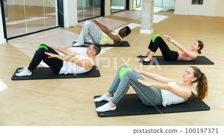 Sporty people training pilates at group class 100197371