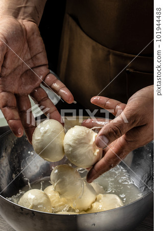 Cheesemaker, showing freshly made mozzarella. The homemade cheese maker produces caciocavallo. Pasta filata, Traditional Italian mozzarella 101944488