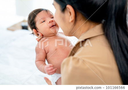 Asian mother hold newborn baby and bring the baby face close to her face look like want to kiss 101166566