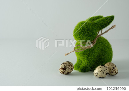 Easter green bunny rabbit figure and quail eggs on light background. Space for you text 101256990