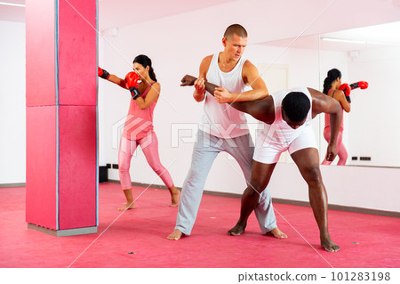 Two men exrcising self defence moves and woman boxing 101283198