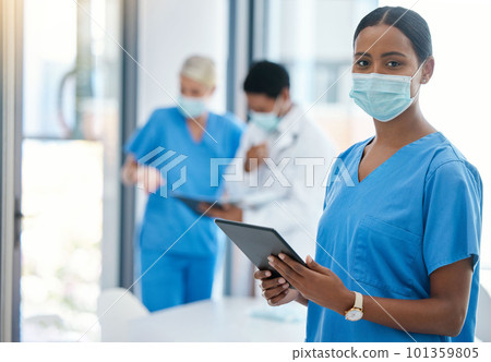 Healthcare, doctor or a nurse on a tablet, consulting in a hospital boardroom. Medical workers meeting to consult, communication online. Covid management and teamwork, doctors wearing surgical masks 101359805