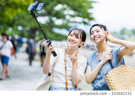 A woman taking a commemorative photo on a girls' trip 103682532