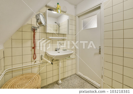 a bathroom with a sink, mirror and towel rack on the wall next to an open door that leads to another room 103218381