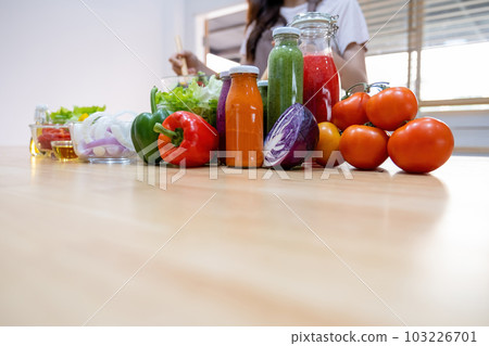 Woman making fresh homemade salad in kitchen. 103226701