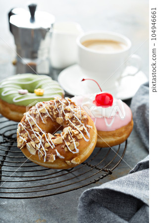 Colorful tasty donuts on a cooling rack 104946661