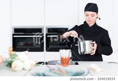 Woman professional is cooking soup in the kitchen 104019834